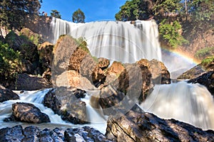 Naturaleza borroso majestuosamente cascada bruto rocas a arcoíris en luz de sol 