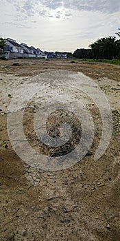 an empty plot of land scene besides a residential row of houses.