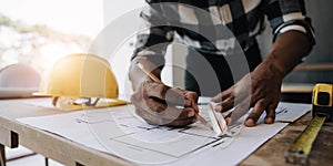 Image of engineer drawing a blue print design building or house, An engineer workplace with blueprints, pencil