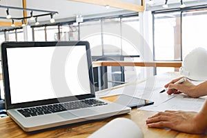 image of engineer hands discussing a building construction project with blank screen laptop at workplace