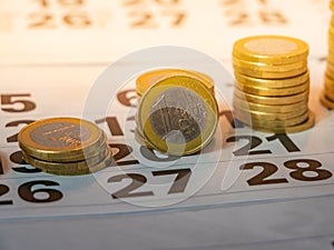 Image of Euro coin stacks on calender indicating pay day