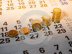 Image of Euro coin stacks on calender indicating pay day