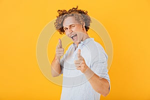 Image of european flirty guy 20s laughing and pointing finger at