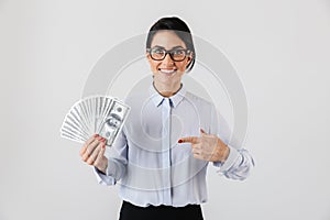 Image of european secretary woman wearing eyeglasses holding bunch of money in the office, isolated over white background