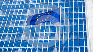 Image of European Union flag with staras over blue background against big modern office building. Concept of ecenomy