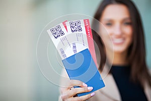 Image of European Woman Having Beautiful Brown Hair Smiling While Holding Passport and Air Tickets