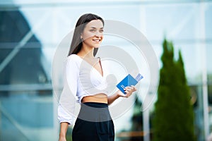Image of European Woman Having Beautiful Brown Hair Smiling While Holding Passport and Air Tickets