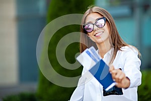 Image of European Woman Having Beautiful Brown Hair Smiling While Holding Passport and Air Tickets
