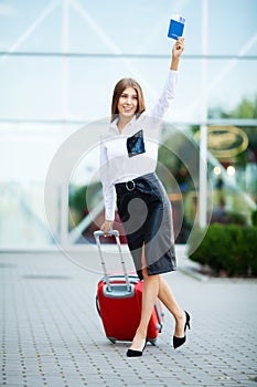 Image of European Woman Having Beautiful Brown Hair Smiling While Holding Passport and Air Tickets.