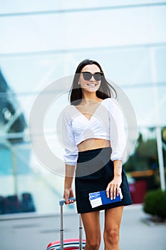 Image of European Woman Having Beautiful Hair Smiling While Holding Passport and Air Tickets.