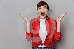 Image of excited brunette woman screaming in wonder and gesturing
