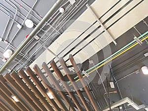 Image of exposed Mechanical system installation above wooden striped pattern of ceiling.