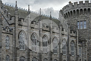 Image of a facade with windows of Dublin Castle with a tower in the background on a typical cloudy day