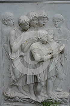 Image of fascinated reading children in stone, stone-carving