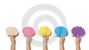 Hands holding colored speech bubbles isolated on white background