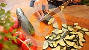Image of female hands cut fresh cucumbers for vegetable salad, nobody