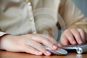 Image of female hands pushing keys of a computer mouse and keyboard