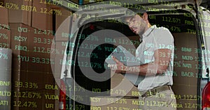 Image of financial data processing over delivery man holding clipboard outside of warehouse