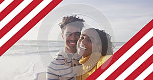 Image of flag of united states of america over biracial couple kissing by sea