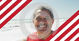 Image of flag of united states of america over senior biracial man on beach