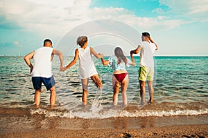 Image of four energetic people jumping at the beach