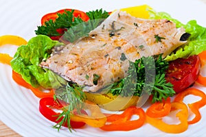 Image of fried trout fillets served with peppers and greens served