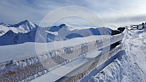Image of frozen fence with beautiful snow covered mountains in the background