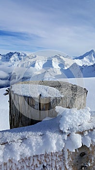 Image of frozen fence with beautiful snow covered mountains in the background