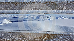 Image of frozen fence with beautiful snow covered mountains in the background