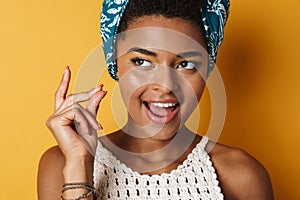 Image of funny african american woman snapping her fingers and laughing