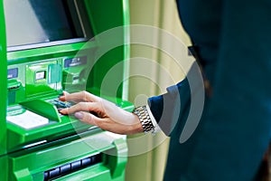 Image of girl picking pincode at green cash dispenser
