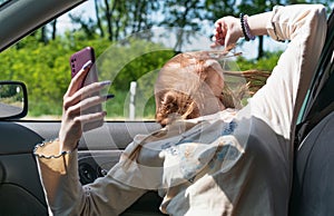 A image of a girl taking pictures of herself in a car