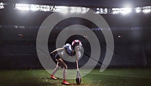 Image of a girl in the uniform of an American football team player preparing to play the ball at the stadium. Sports concept