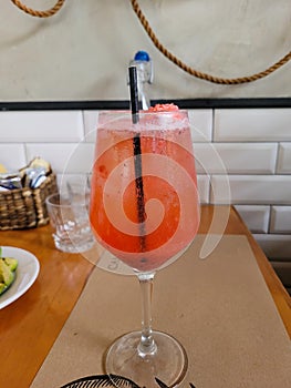 Image of a glass of aperol spritz cocktail on a wooden table in a restaurant