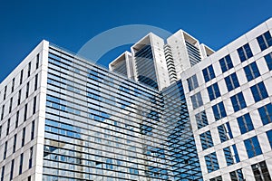 Image of glass skyscraper office buildings with blue sky. Business concept.