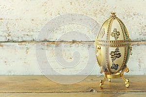 Image of gold faberge egg on wooden table