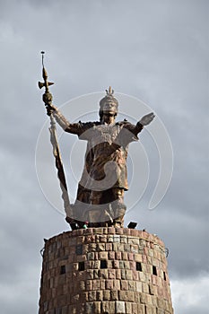 Image of a golden Inca's sculpture in a monument. Traditional icon in Cusco Peru