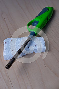 Green Utility Lighter and Firelighter Brick on Wooden Surface