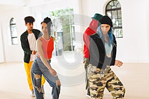 Image of group of group of diverse female and male hip hop dancers practicing in dance studio