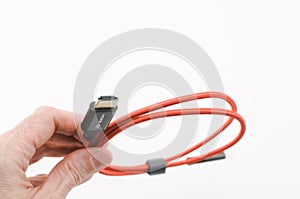image with hand holding compuer cables and wires on a white surface