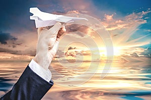 Image of a hand holding a paper airplane. Tourism concept