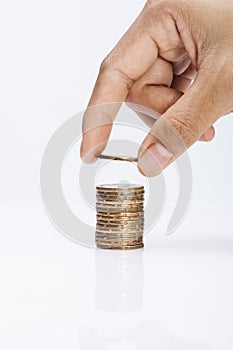 Image of Hand put coins to stack of coins on white background background-saving concept