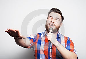 Image of a handsome man singing to the microphone.