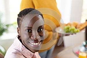 Image of happy african american woman smiling at camera