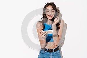 Image of happy beautiful woman using cellphone and laughing