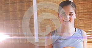 Image of happy caucasian girl holding basketball