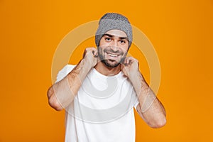 Image of happy man 30s with beard and mustache smiling while standing, isolated over yellow background