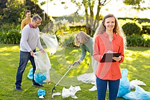 Image of happy multi generation caucasian family collecting waste in garden