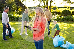 Image of happy multi generation caucasian family collecting waste in garden