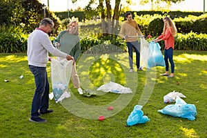 Image of happy multi generation caucasian family collecting waste in garden